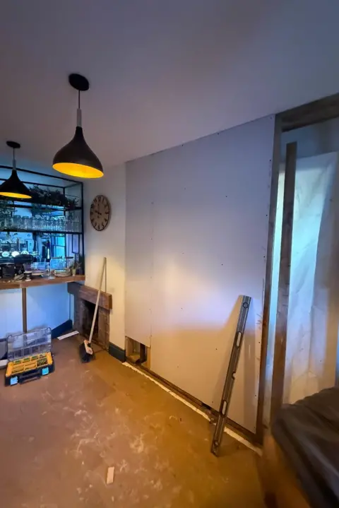 Mark Nundy A newly inserted plasterboard wall can be seen in the interior of the pub, surrounded by tools, brushes and spirit levels.