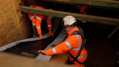 Stuart Ratcliffe/BBC Anglian Water engineers working on a pipe