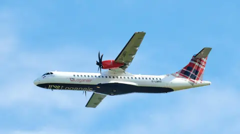 A Logan Air plane pictured in the air. A blue sky is visible in the background. 