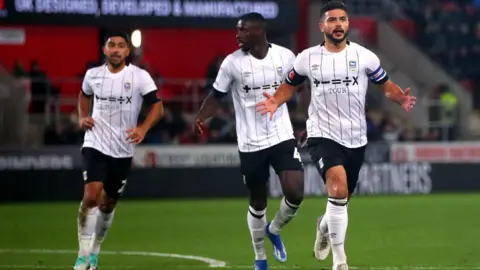 Simon Marper/PA Media Ipswich Town captain Sam Morsy runs across the pitch, followed by team-mates