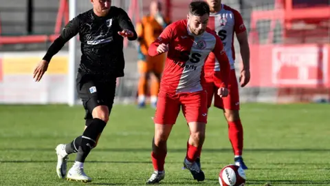 Getty Images Barrow's Ritchie Bennett tussles with Ashton's Matty Regan