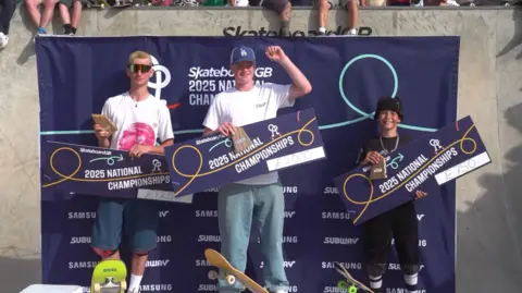 Skateboard GB/Leo Sharp Cunningham on the podium of the Skateboard GB National Championships after winning the junior category for the second time