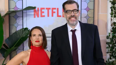 Getty Images Ingrid Oliver in a red dress and Richard Osman at the Netflix UK premiere of the adaptation of The Thursday Murder Club