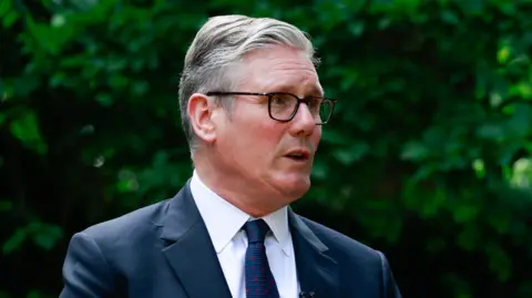 Keir Starmer wearing a suit, standing in the Downing Street garden