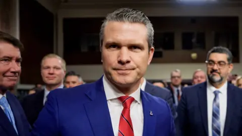 Pete Hegseth stares into the camera with respective  men successful  suits down  him.