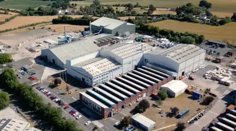 Bridgnorth Aluminium An aerial view of the Bridgnorth Aluminium factory with vehicles surrounding it and fields in the background 