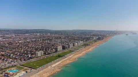 Brighton & Hove City Council An aerial photo from the sea showing Brighton and Hove. In the foreground running parallel to the sea is the green space which is now Hove Beach Park. It was mostly grass and there was a pitch and putt golf course.