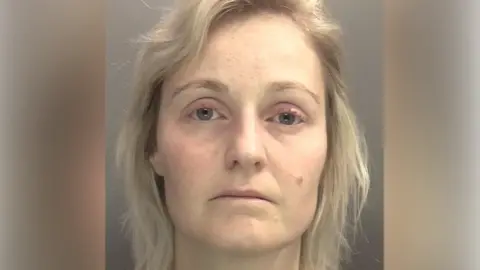 West Midlands Police A mug shot of a woman with shoulder length blonde hair.