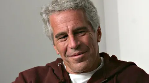 Billionaire Jeffrey Epstein wears a brown hooded sweatshirt that says Harvard while in Cambridge, Massachusetts in 2004.