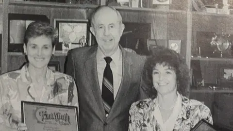 Wiltshire Community Foundation Anna Marsden (left) and Ann Poole (right) and a man staring into the camera. It is a newspaper photo published in 1990.