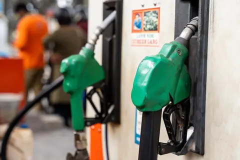 NurPhoto via Getty Images Fuel nozzles hang at a petrol pump at a fuel station in Guwahati, India