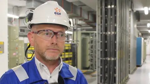 George King/BBC Gavin Rousseau - a Sizewell B employee. He is wearing a hard hat and glasses and looking just past the camera