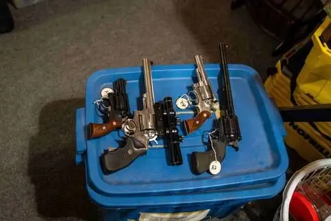 RCMP Small firearms are laid on a blue container and tagged in a Dauphin, Manitoba home.