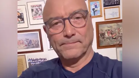 Instagram Man with glasses in navy T-shirt looks at camera