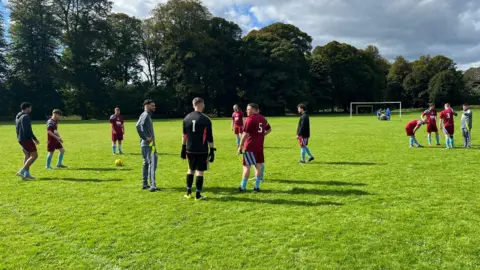 Avenue Hotspur Players from Avenue Hotspur are seen talking amongst themselves connected  the transportation   earlier  the game