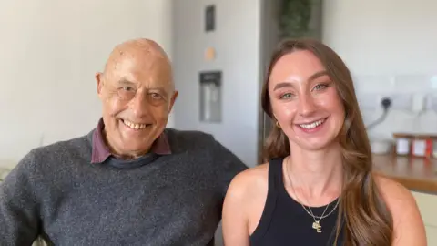 Both nurse and patient sat next to each other smiling