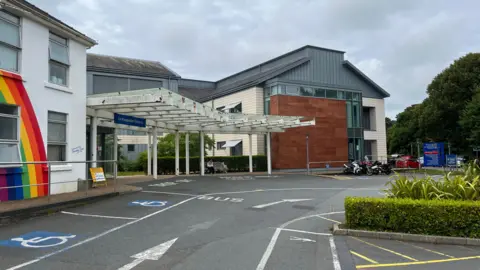 BBC An entrance at Princess Elizabeth Hospital in Guernsey. One of the buildings has a rainbow painted on it.