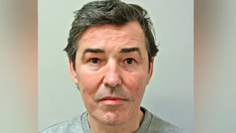 Lancashire Police Image shows Darren Davies, who has short dark hair and is wearing a grey prison-issue sweatshirt