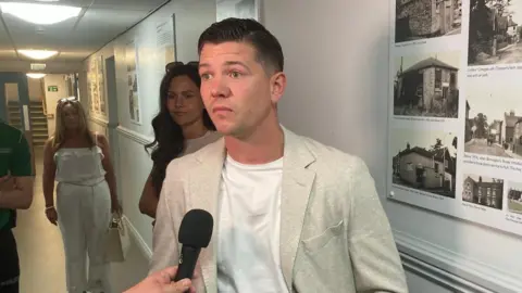 Luke Campbell arrives at the count for the Hull and East Yorkshire mayoral election. He is wearing a light coloured jacket and white shirt.