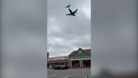Screengrab of a video showing a plane flying at low altitude over a building in Moscow