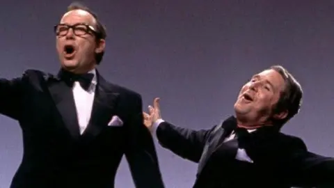 Morecambe and Wise break into song in their bow ties and dinner suits