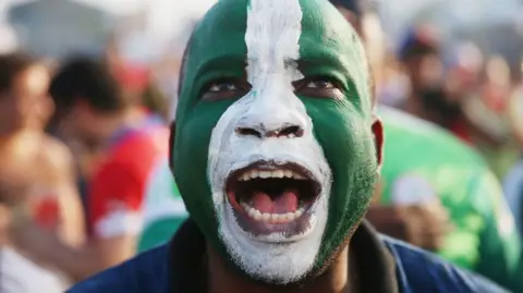 Getty Images A man with a Nigerian flag painted on his face