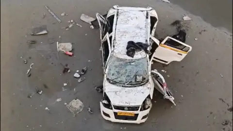 Photo of a car that fell of an unfinished bridge in Uttar Pradesh state.