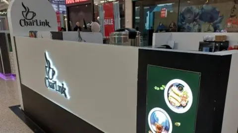 Luton Borough Council A close up of the white and brown Chai Link kiosk where the mice infestation was found. Equipment used to make drinks and food can be seen. 