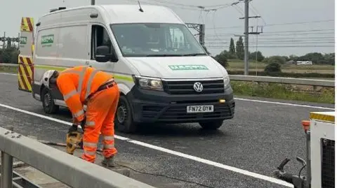 Bedford Borough Council A workman working on a crash barrier on the A6, Bedfordshire