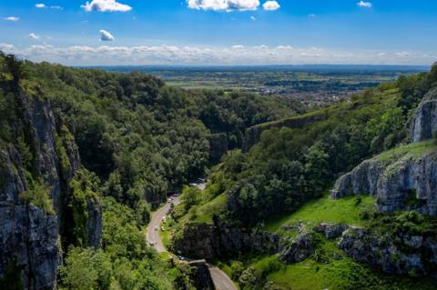 An aerial picture of Cheddar Gorge on a sunny day with the Somerset Levels in the distance