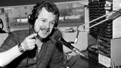 Getty Images A black and white photo of James Whale on Metro Radio in Newcastle in the 1970s