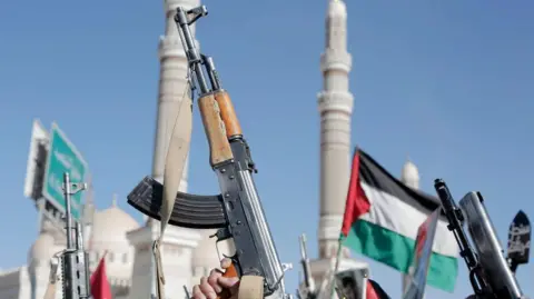 Getty Images Yemen's Houthi followers brandish weapons and chant slogans 