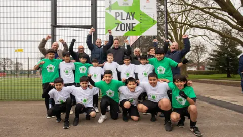Football Foundation Pupils from Dale Community Primary school with other representatives from Derby City Council, the Football Foundation and the Premier League cheering in front of new court