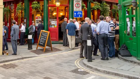 Pub drinkers standing outside a pub in London