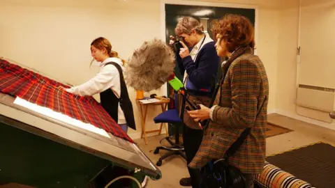 Alchemy Festival Film makers at work in a Borders textile factory looking at the material made