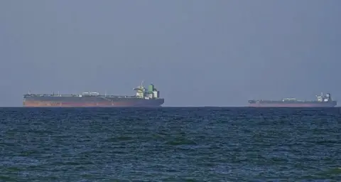 Getty Images Two tankers on the horizon, with ocean in the foreground, as they head toward the Strait of Hormuz.