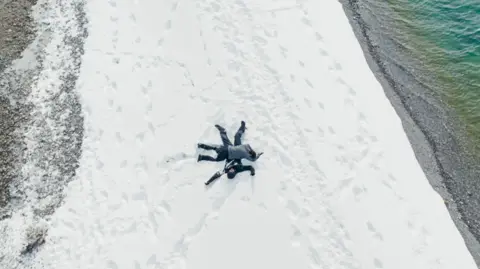 BBC/Studio Lambert Kush lies on top of Jo who is spreadeagled on ice in Hatgal, Mongolia.