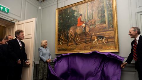 Queen Camilla unveiling a picture in Palace House during a visit to the National Horseracing Museum in June 2023