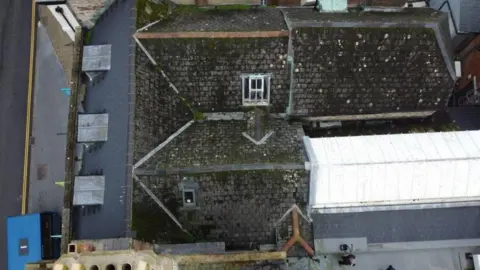 Crickmay Stark Aerial view of the grey pitched roofs of Dorset Museum