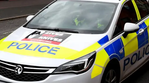 A Hertfordshire police car, you cannot see the face of the officer driving it