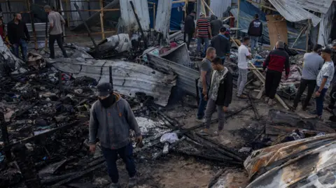 EPA Palestinians search through the ruins of the destroyed camp 