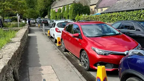 Cars parked along a street in Bibury