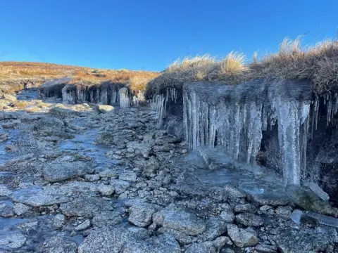 Jana Bartschova Icicles hang down into a frozen burn with rocks in Cairnsmore of Fleet, Galloway