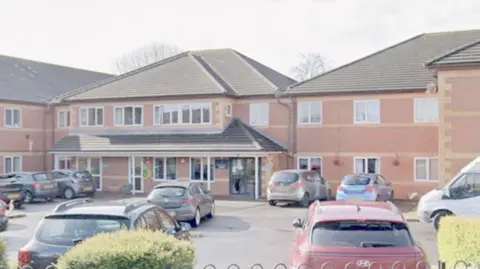 A Google Streetview snapshot of Donwell House Care Home in Washington. The large red-brick building is over two storeys and has a car park on the front.