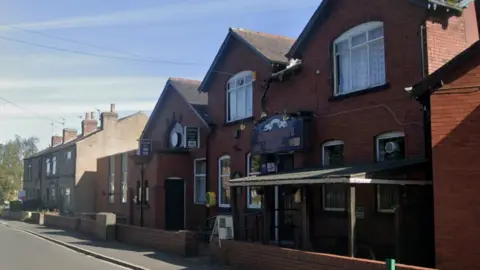 A red brick, single-storey building on a residential street. Signage outside reads 'Alverthorpe Working Men’s Club'.