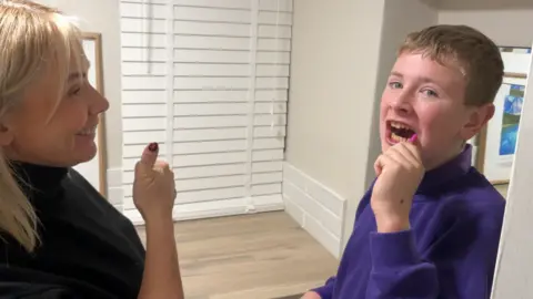 Mark Ansell / BBC Anne-Marie giving a thumbs up to her son Fredi who is successfully brushing his teeth.