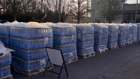 Carterton Town Council Stacks of bottled water set up in a car park