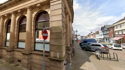 Google An historic building, derelict with a for sale sig in the window