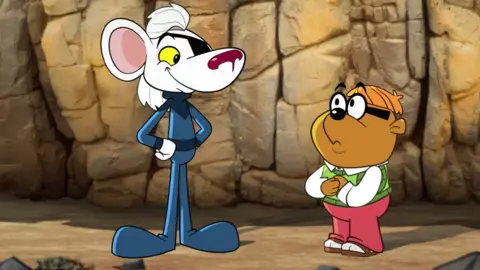 Danger Mouse and Penfold from the show's reboot. The cartoon mouse is wearing a blue suit and an eye patch. Penfold is a hamster wearing a white shirt, green waistcoat and red trousers. He also wears a pair of glasses.