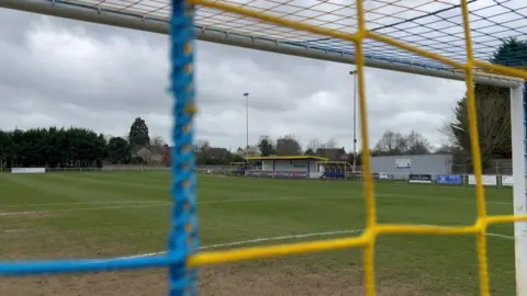 BBC Northcourt Road has a small yellow and blue stand and two dugouts looking out over the pitch.